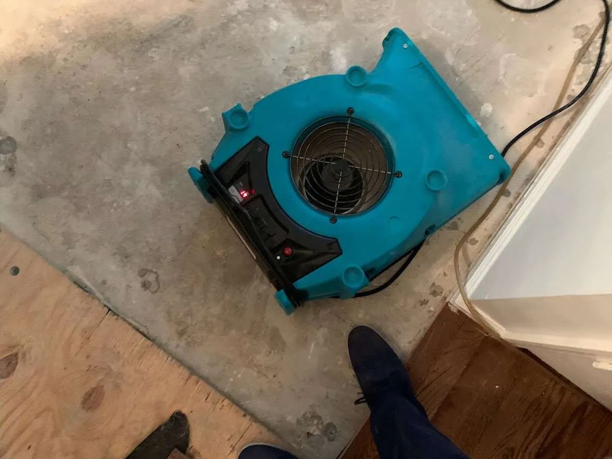 Air mover drying subfloor during Commercial Water Damage Restoration in Tonganoxie